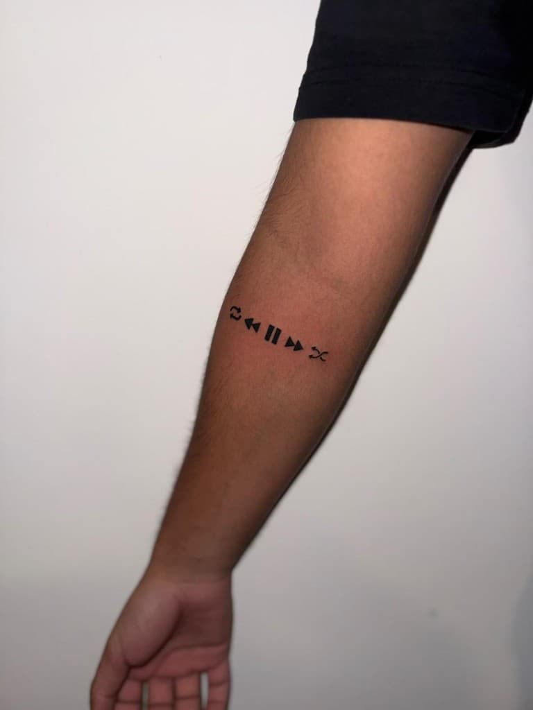 Crni simboli muzičkog plejera (ponavljanje, nazad, pauza, napred, mešanje) na podlaktici